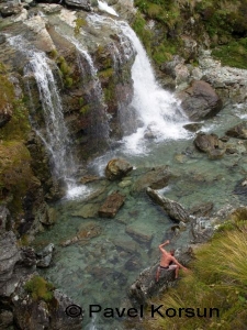 Мужчина пробирающийся по камням возле великолепного водопада Рутберн Фолс  