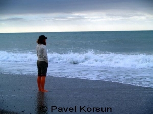 Девушка на пляже смотрит на бесконечный безбрежный океан