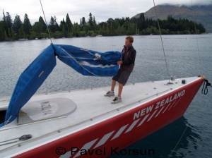 Молодой яхтсмен вытаскивает стаксель из форпика яхты "Новая Зеландия"