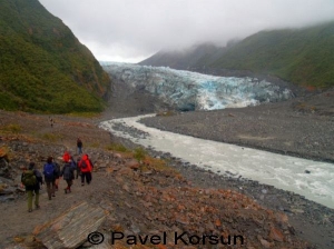 Группа туристов идет возле ледниковой реки недалеко от ледника Фокс