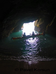 Два туриста на каяке внутри пещеры в районе Соборной бухты