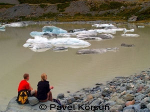 Две девушки наблюдающие обломки-айсберги ледника плавающие в ледниковом озере