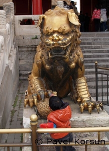 Бронзовая статуя дракона не дает маленькому мальчику мяч