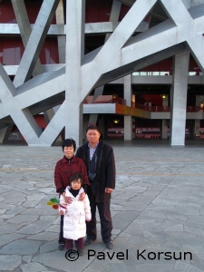 Папа, мама и девочка возле Пекинского олимпийского стадиона