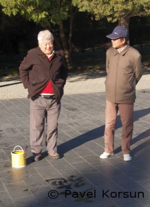 Китаец-пенсионер, рисующий иероглифы на площади