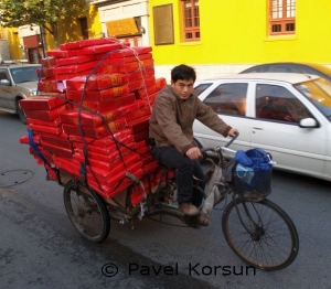Велорикша везет товар в красных коробках