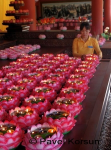 Ритуальные цветы лотоса со свечами и девушка прислужница