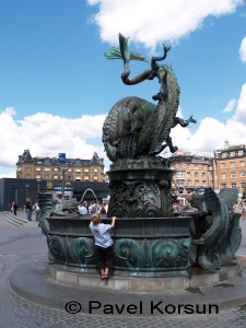 Маленький мальчик смотрит на фонтан  "Бык, раздирающий дракона" на Ратушной площади Копенгагена