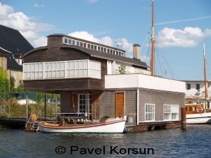 Двухэтажный дом на воде и лодка у входа