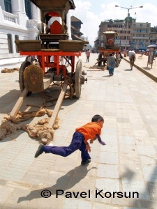 Мальчик делает прыжок перед повозкой для Богини Кумари