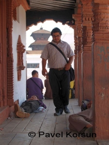 Непалец на верхней площадке храма среди спящих бездомных людей