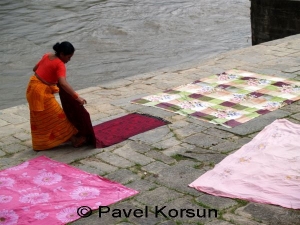 Непальская женщина высушивает покрывала