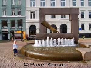 Ребенок стоит возле фонтана с указывающей рукой в Осло