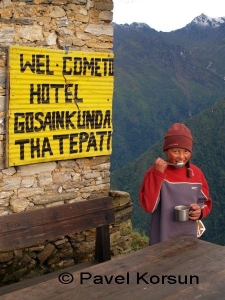 Девочка-непалка пьет чай у горного отеля Тарепати