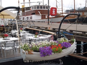 Спасательная лодка стала клумбой для цветов возле кафе на набережной Осло