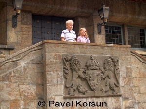 Мальчик и девочка стоят на балконе замка Акерсхус как король и королева