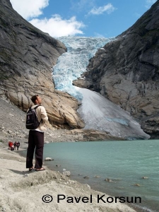 Мужчина на берегу озера питающегося от Бриксдальского ледника