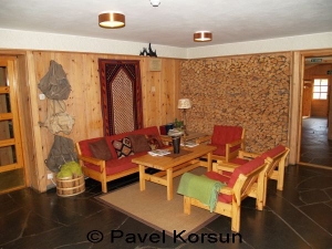 Гостинная- прихожая в отеле "Grotli Hoyfjellshotel" - стол, стулья, рюкзаки и поленья