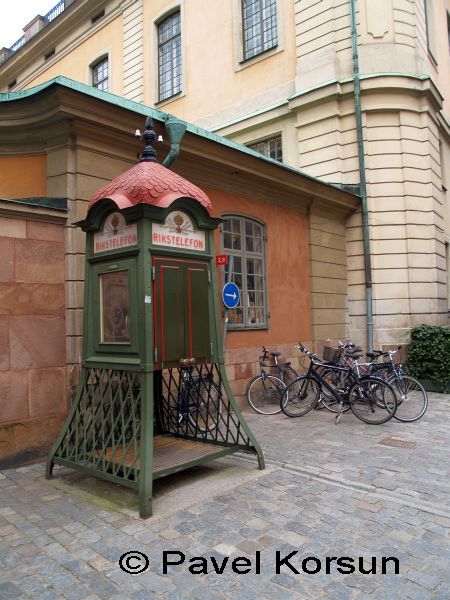 Старинная телефонная будка и несколько велосипедов на улице Стокгольма