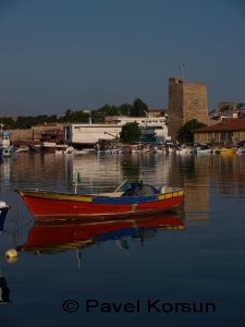 Рыбацкая лодка на фоне оборонительной башни в гавани города Синоп