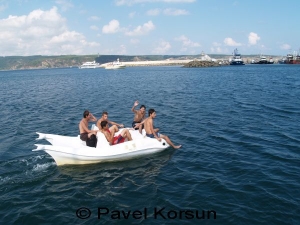 Парни катаются на пляжном катамаране в бухте у черноморского входа в пролив Босфор