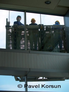 Работники чистящие окна небоскреба на последнем этаже