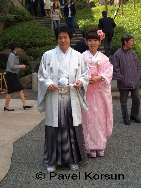 Молодожены японцы в классических японских свадебных одеждах в парке