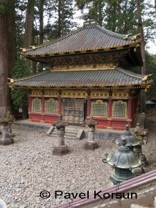 Красная оборонительная двухэтажная пагода с каменными фонарями на входе