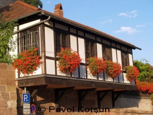 Балкон дома украшенный красными цветами