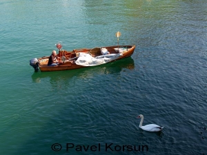 Рыбак на лодке и белый лебедь