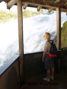 Женщина смотрит на мощный поток Рейнского водопада
