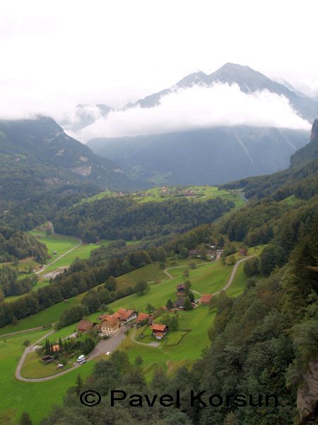 Поселение в долине среди гор в райное Рейнбахского водопада и облако плывущее ниже вершины горы
