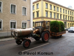 Городской трактор перевозящий зеленые насаждения и кусты
