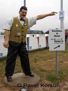 Рекламная статуя мужчины у дороги предлагающего перекусить и поспать